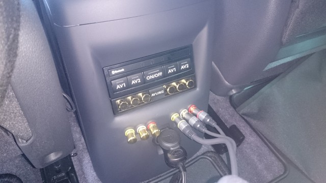 Console modifiée avec ajout de 2 x 3 RCA AV (1 en entrée aux du Kenwood pour brancher un Bluray nomade et 1 en sortie aux du Kenwood pour envoyer les signaux AV vers l'arrière et pontables avec les entrées RCA du pack vidéo pour alimenter les écrans d'appui-tete d'origine ou envoyer le son dans les casques audio bluetooth)